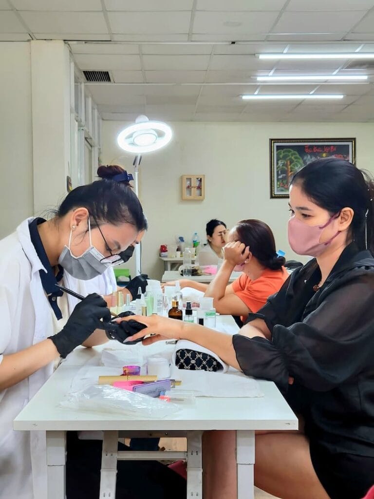 Lớp học đắp bột móng tay tại Jasmine – Học viên thực hành trên mẫu thật cùng giáo viên hướng dẫn