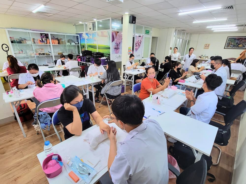 Học viên lớp Nail tại Jasmine thực hành chăm sóc móng tay trên mẫu thật trong giờ học