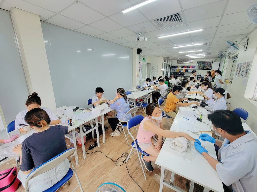Học viên thực hành chăm sóc móng và sử dụng dầu dưỡng móng tay tại lớp học nail Jasmine