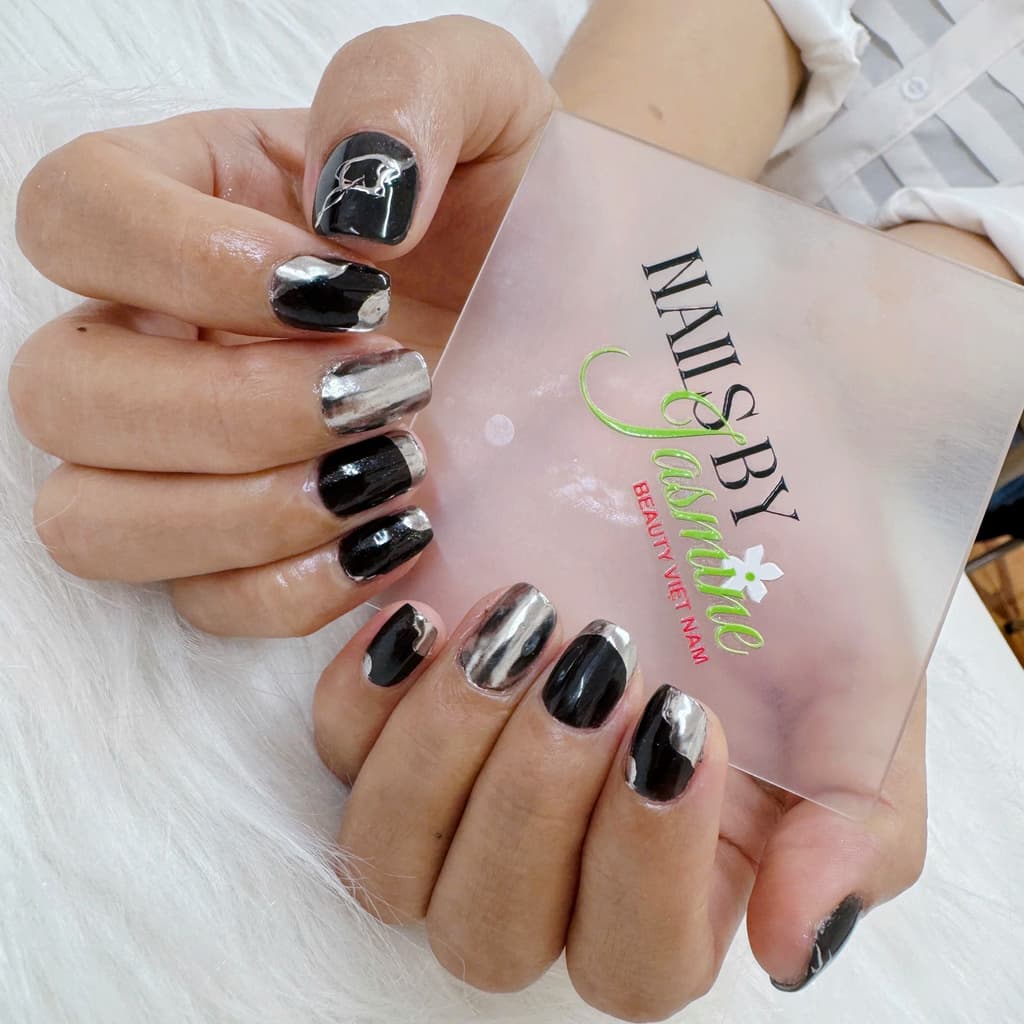 Bộ móng chrome đen phối ánh bạc với hiệu ứng ánh kim mạnh mẽ, tạo cảm giác cá tính và hiện đại, phù hợp phong cách unisex, do học viên Jasmine thực hiện