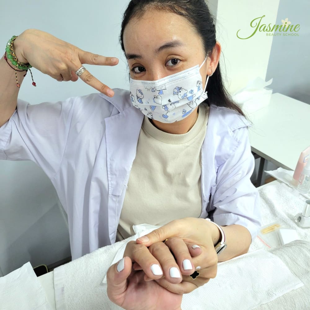 học viên đang luyện cách sơn gel móng tay đúng cách trên mẫu thật tại lớp thực hành Jasmine