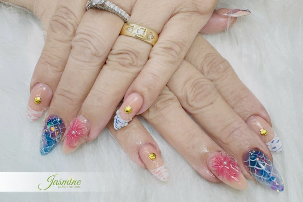 Mẫu nail 3D và vảy cá cho học viên nâng cao – sử dụng kỹ thuật đắp gel hoa nổi, vẽ họa tiết vảy cá ánh kim và đính charm nhũ vàng trên nền móng dài.