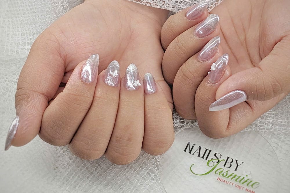 Mẫu nail đắp bột tay thật kết hợp tráng gương, mắt mèo và charm ngọc tạo hiệu ứng trong suốt bắt sáng.