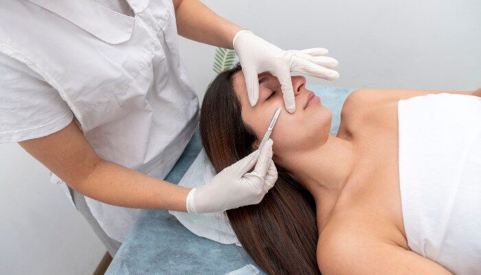 Chuyên viên chăm sóc da thực hiện tẩy da chết bằng dao y khoa (dermaplaning)